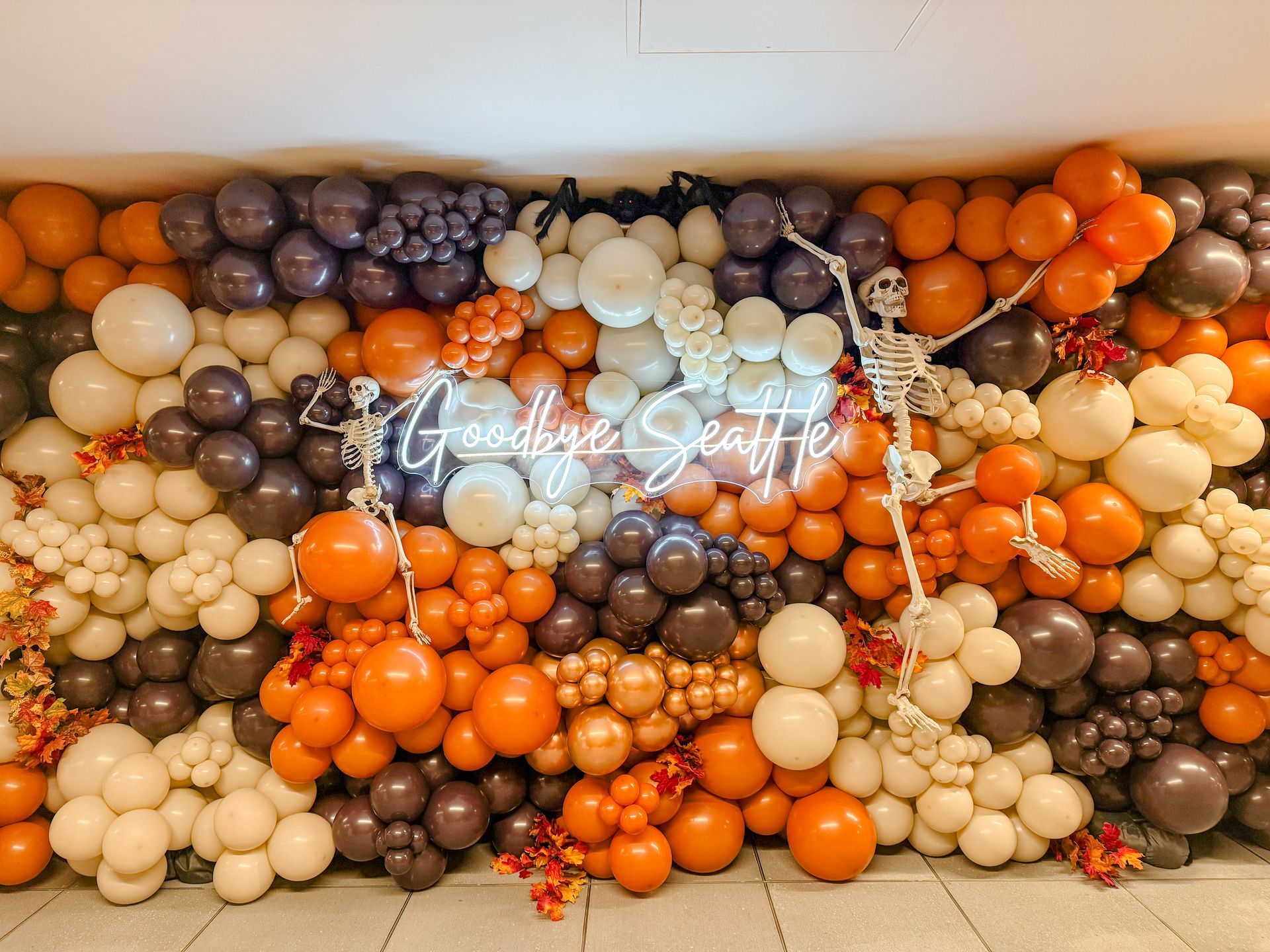 A wall filled with balloons and a skeleton.