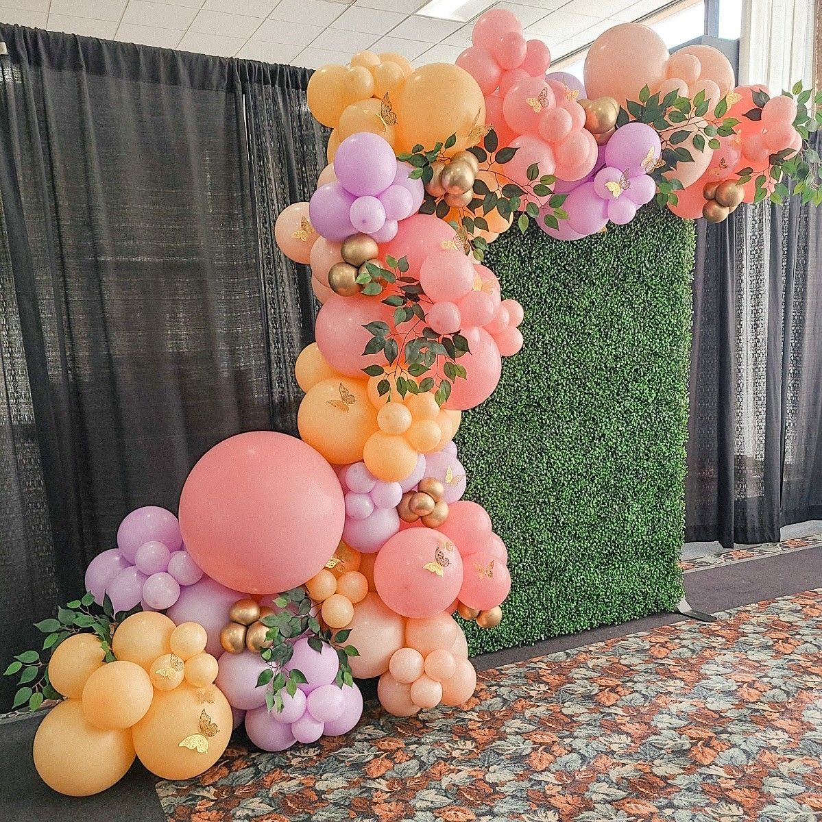A bunch of balloons are sitting in front of a green wall.