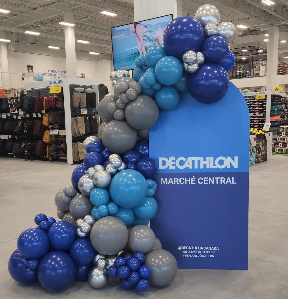 A decathlon sign is surrounded by blue and gray balloons