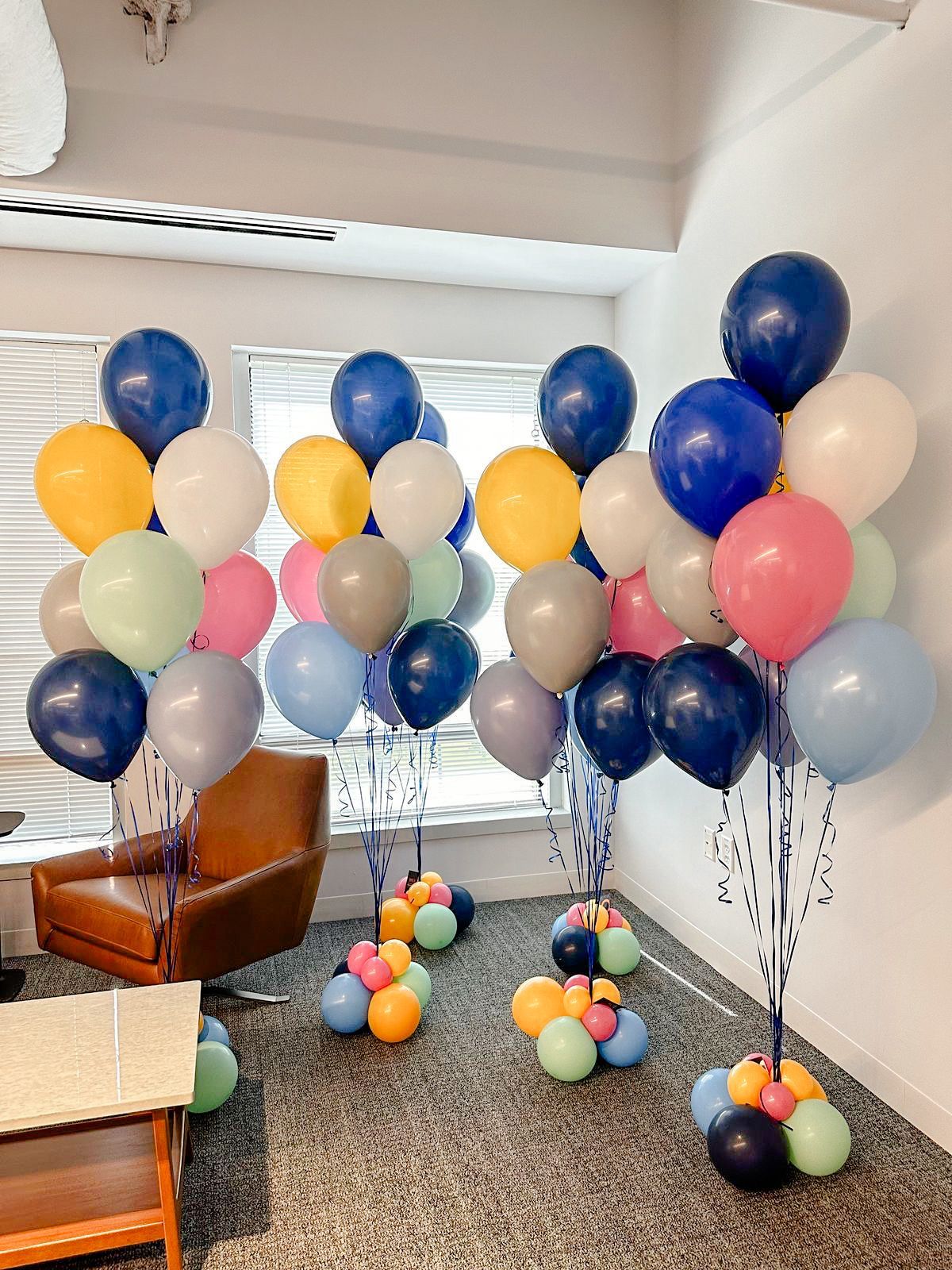 A bunch of balloons are sitting on the floor in a room.