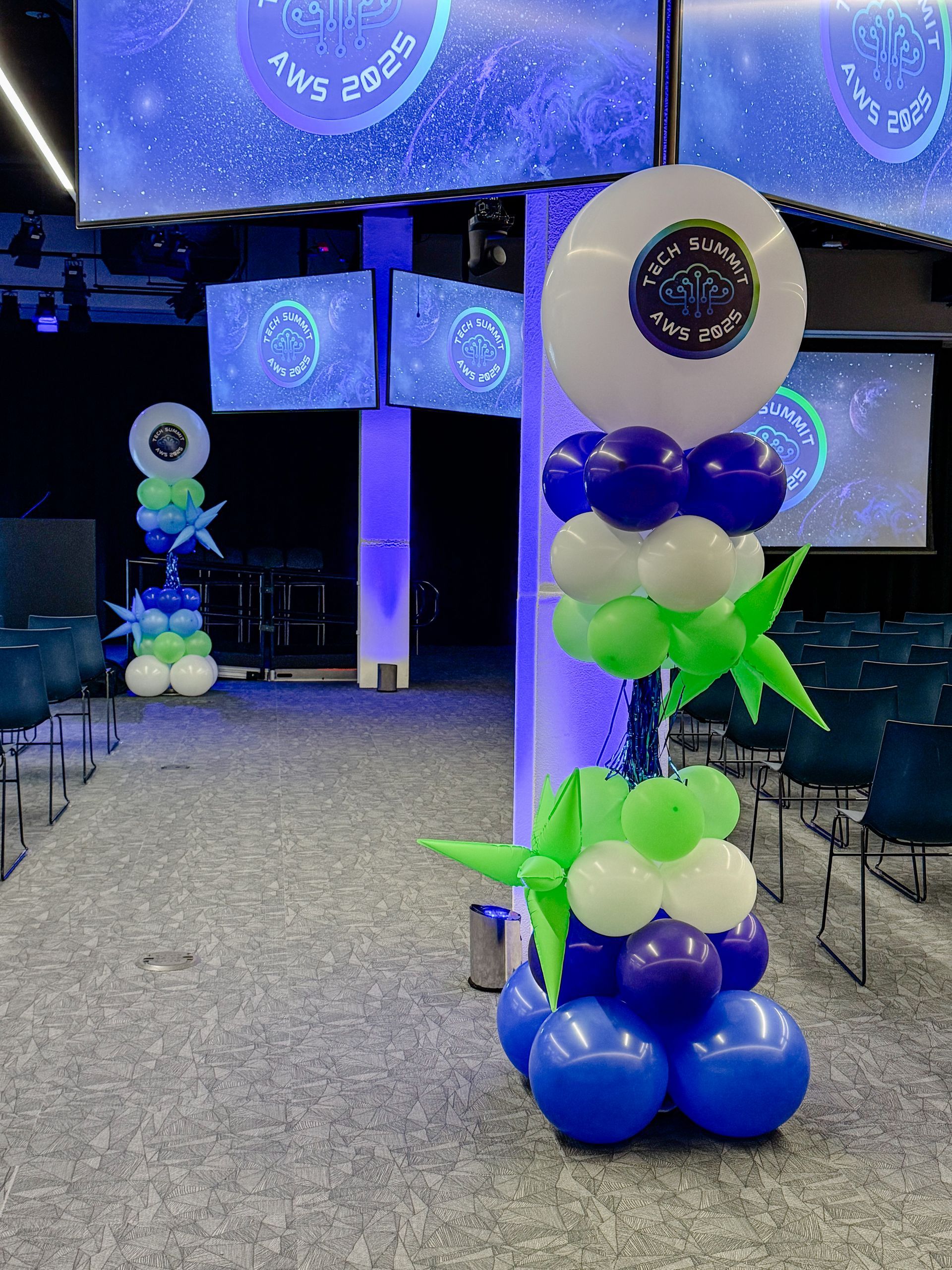 Balloon decorations in a conference room with blue and white colors and starry backgrounds.