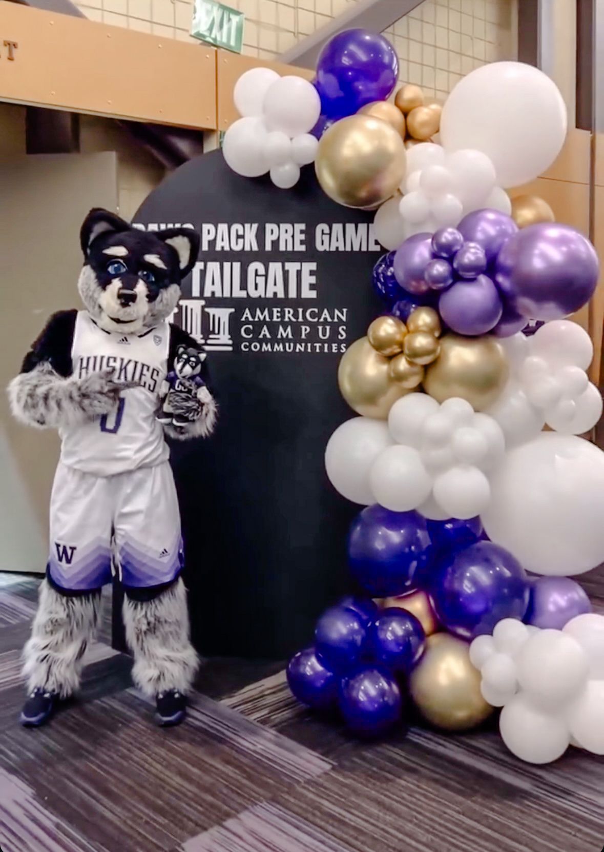 A mascot is standing in front of a sign that says pack pre game tailgate