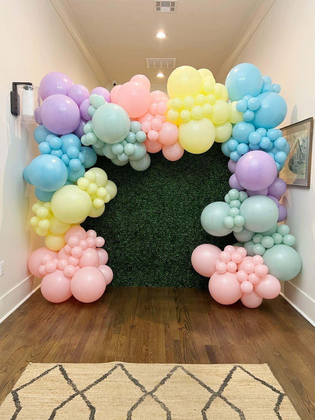 A hallway filled with colorful balloons and a rug.
