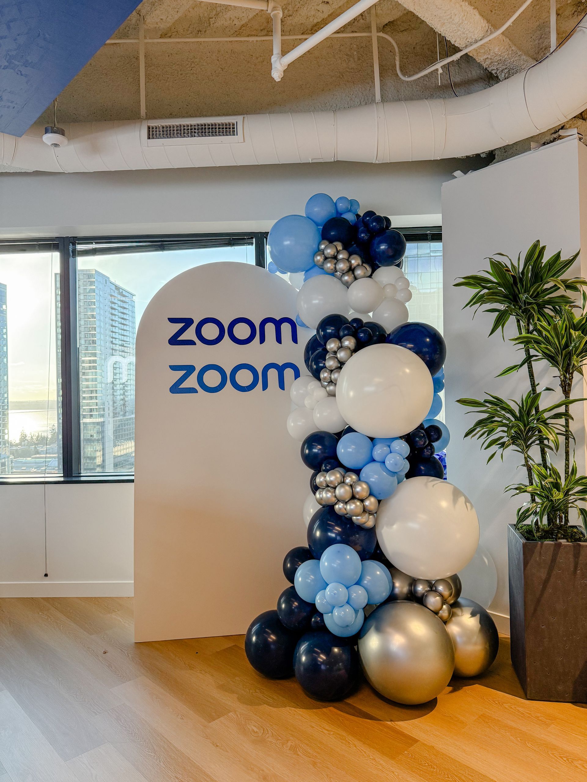 A room with balloons and a sign that says zoom zoom