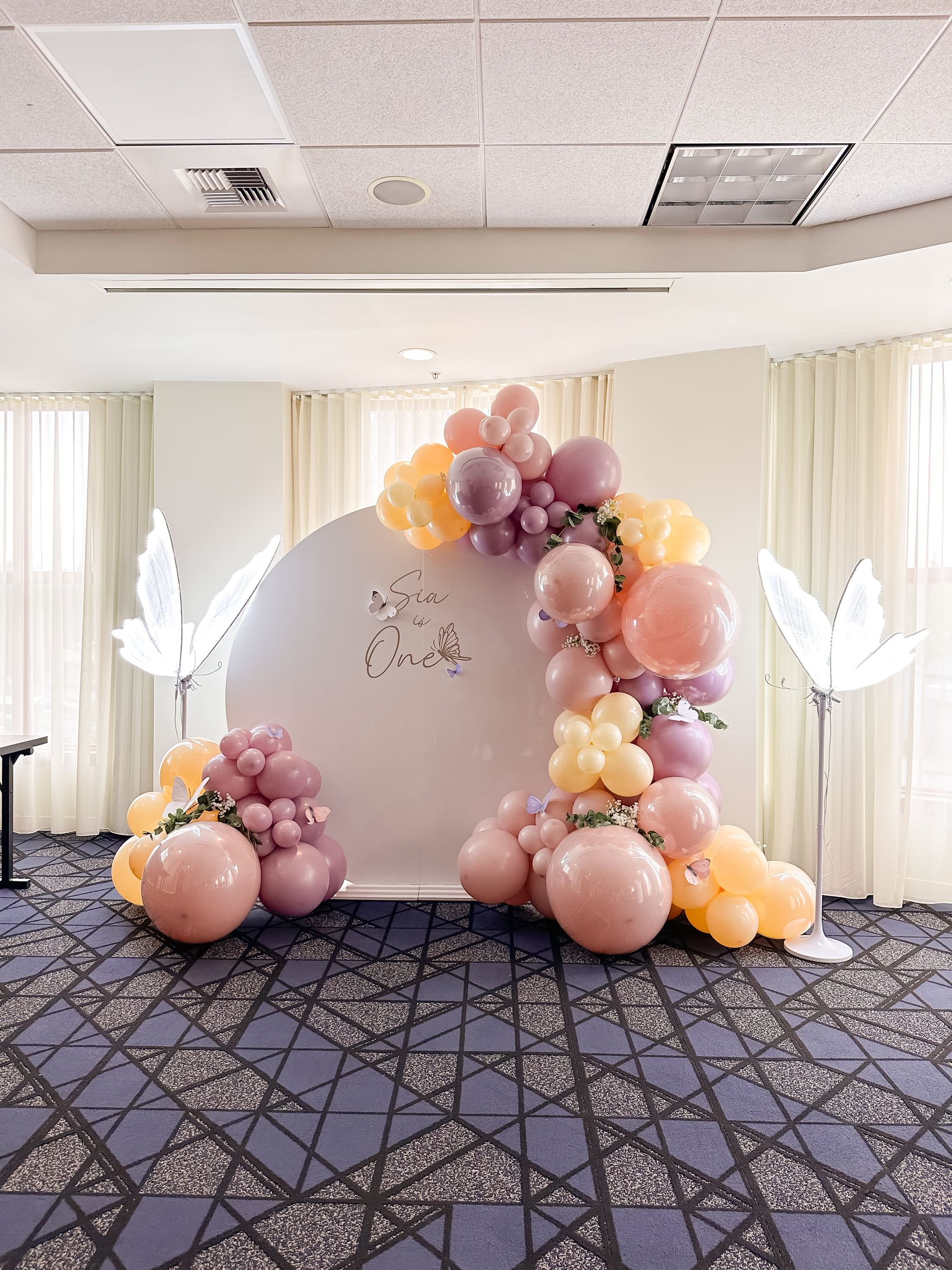 A room filled with balloons and a white wall.