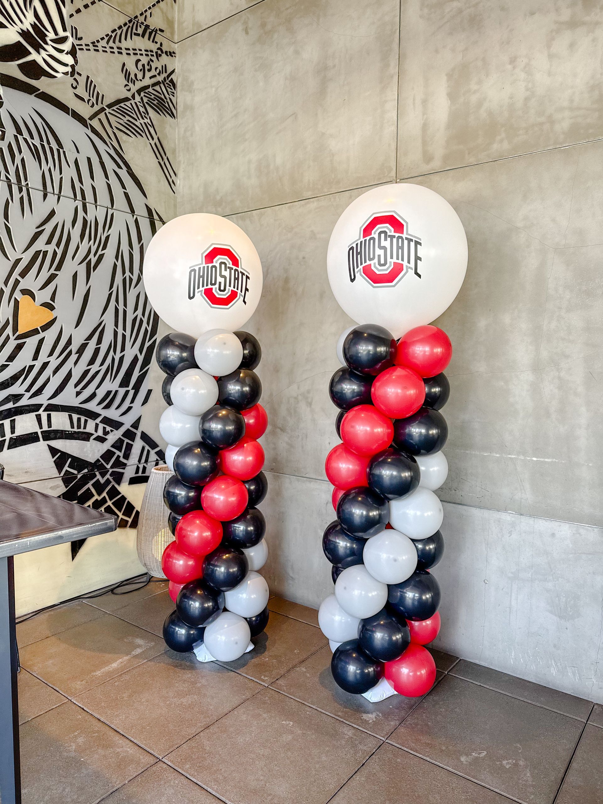 Two balloon columns, black, red, and white, topped with Ohio State logo balloons.