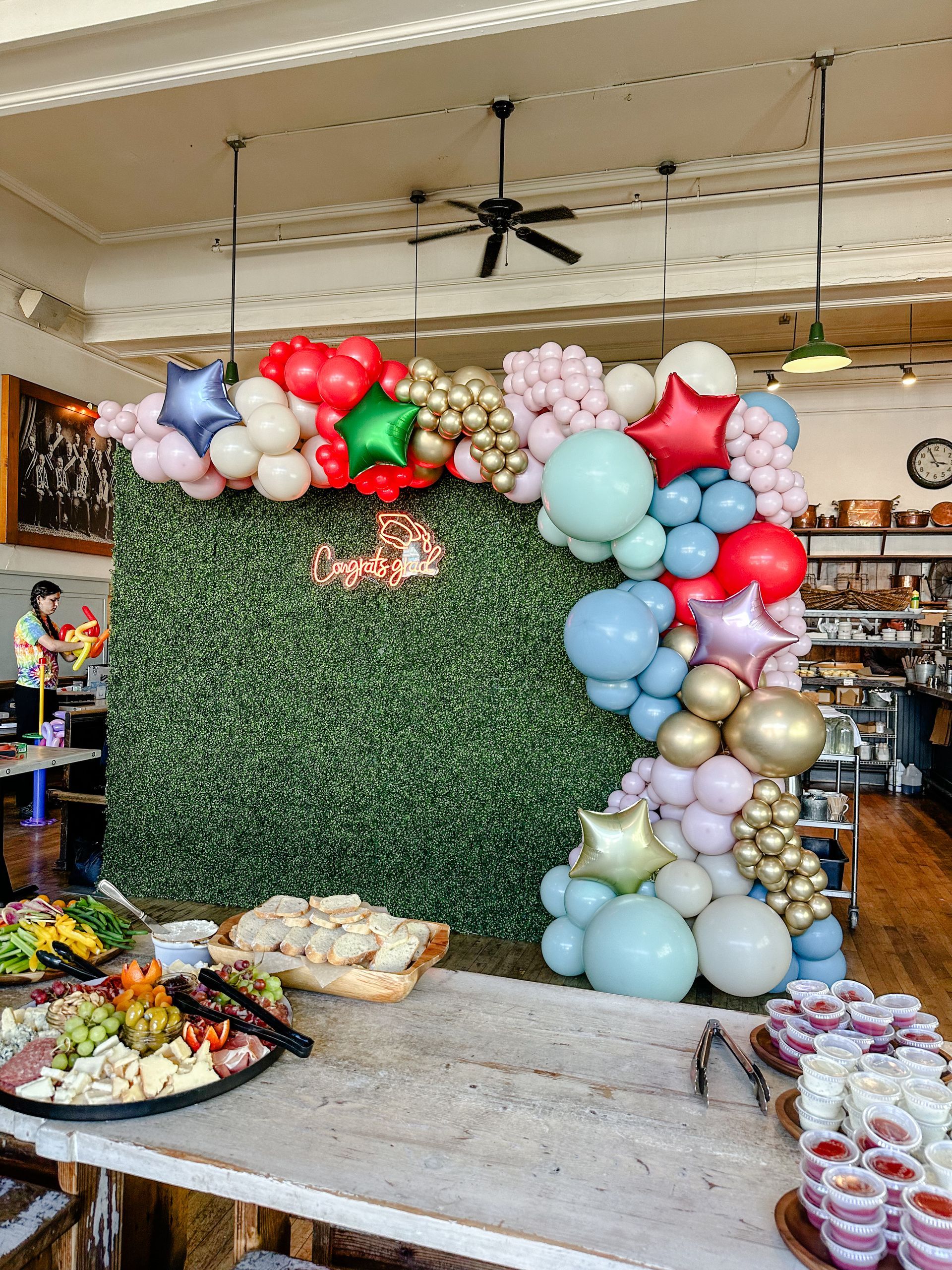 A restaurant with a buffet table and balloons on the wall.