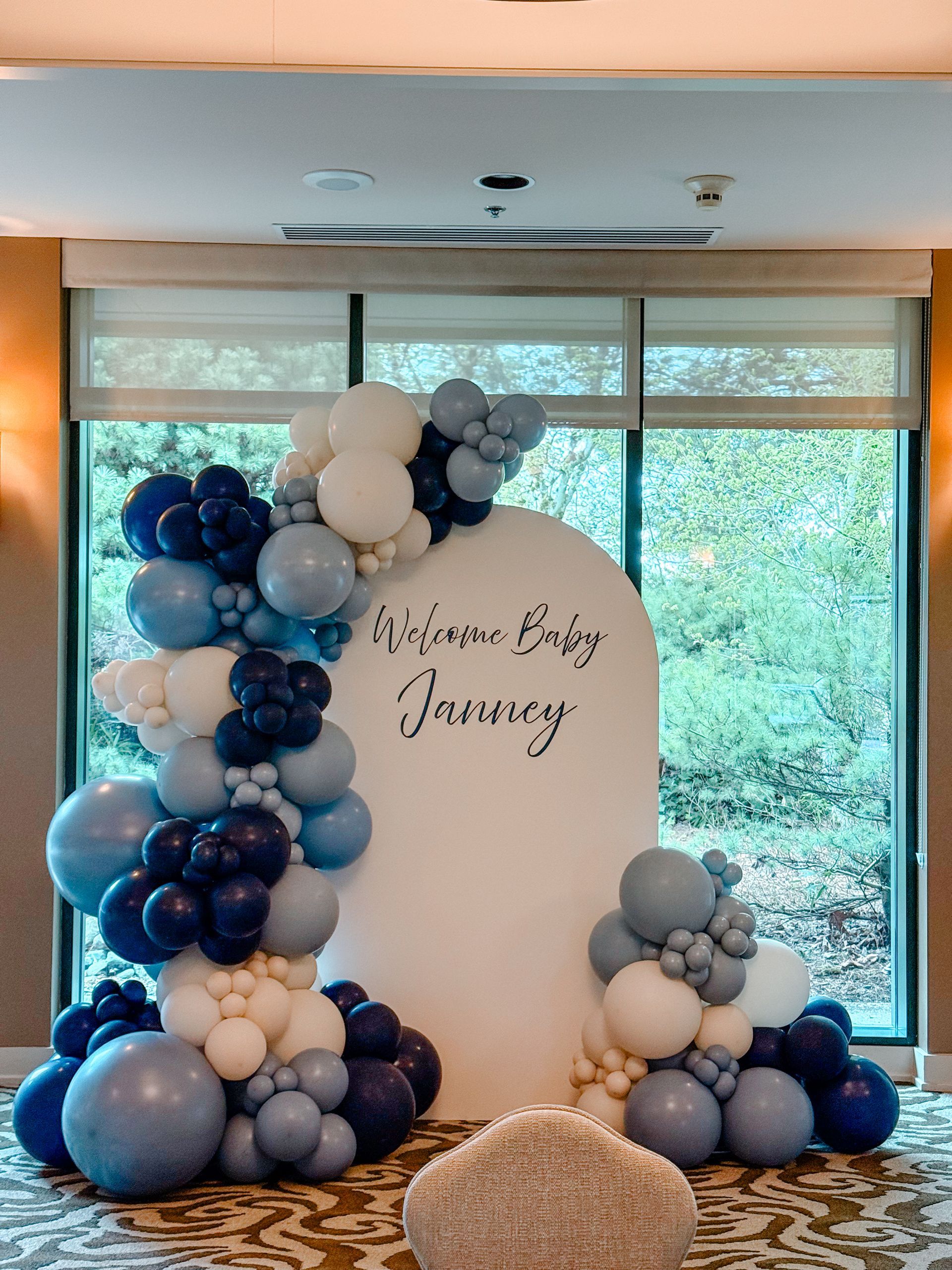 A wall covered in white and gold balloons and flowers.