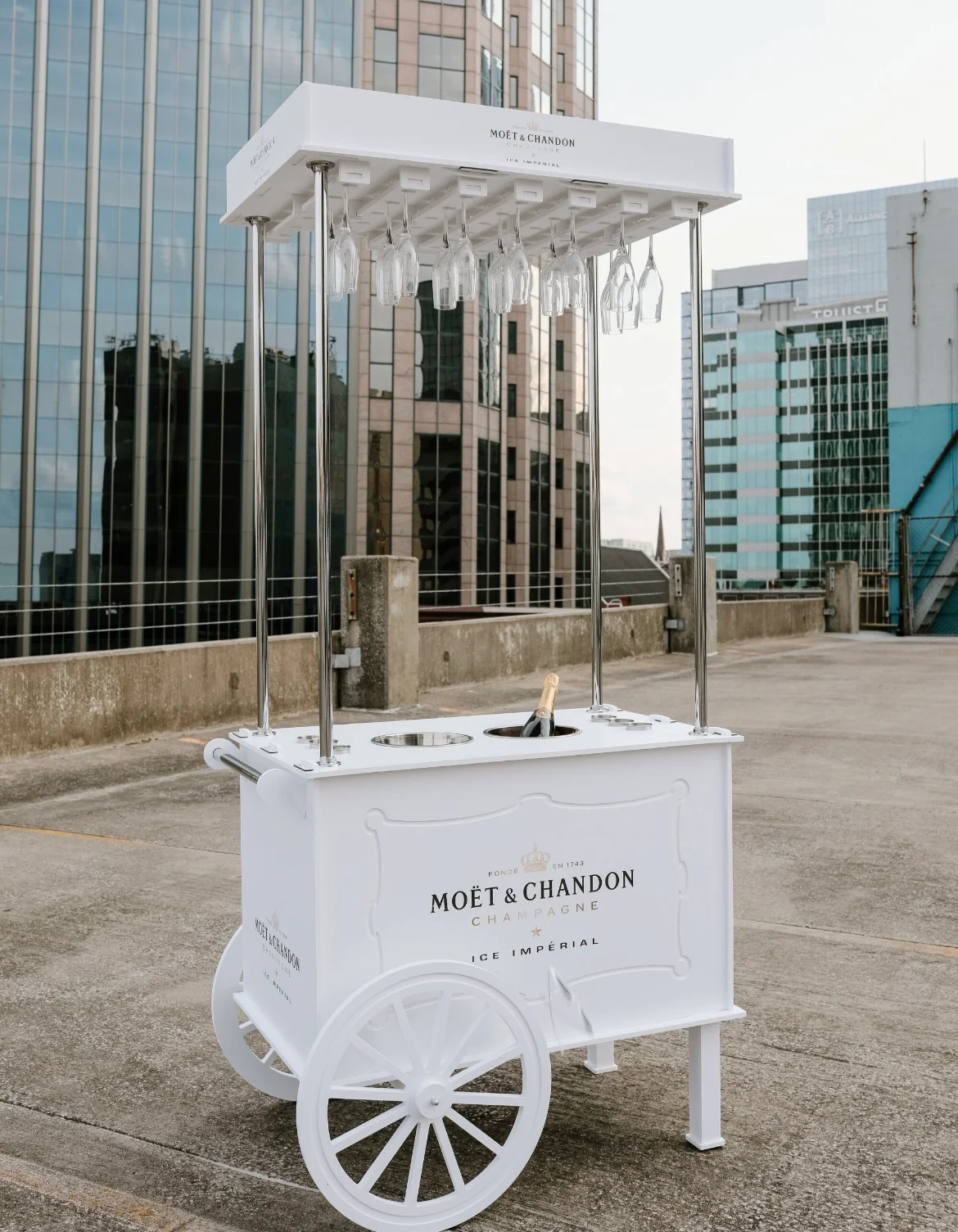 A white cart is sitting on the ground in front of a building.