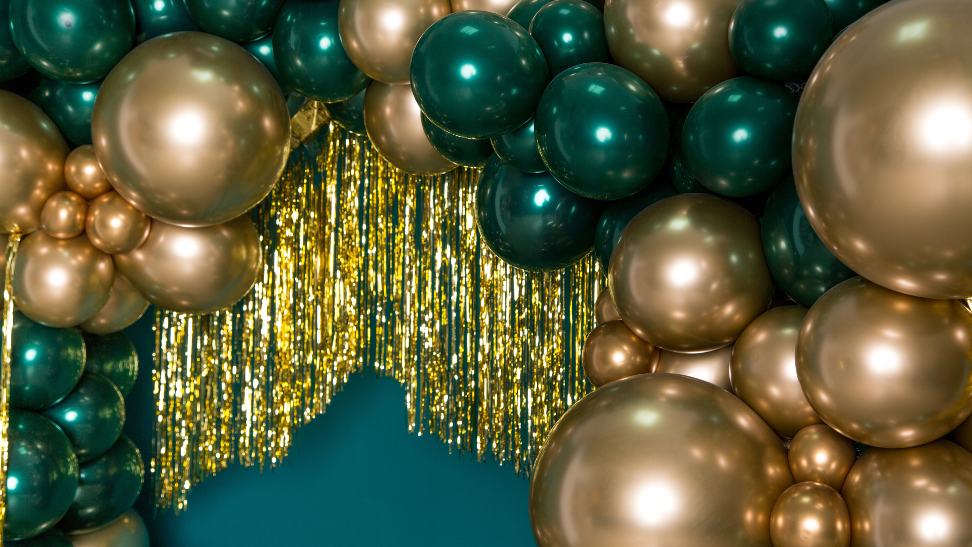 A bunch of gold and green balloons on a blue background.