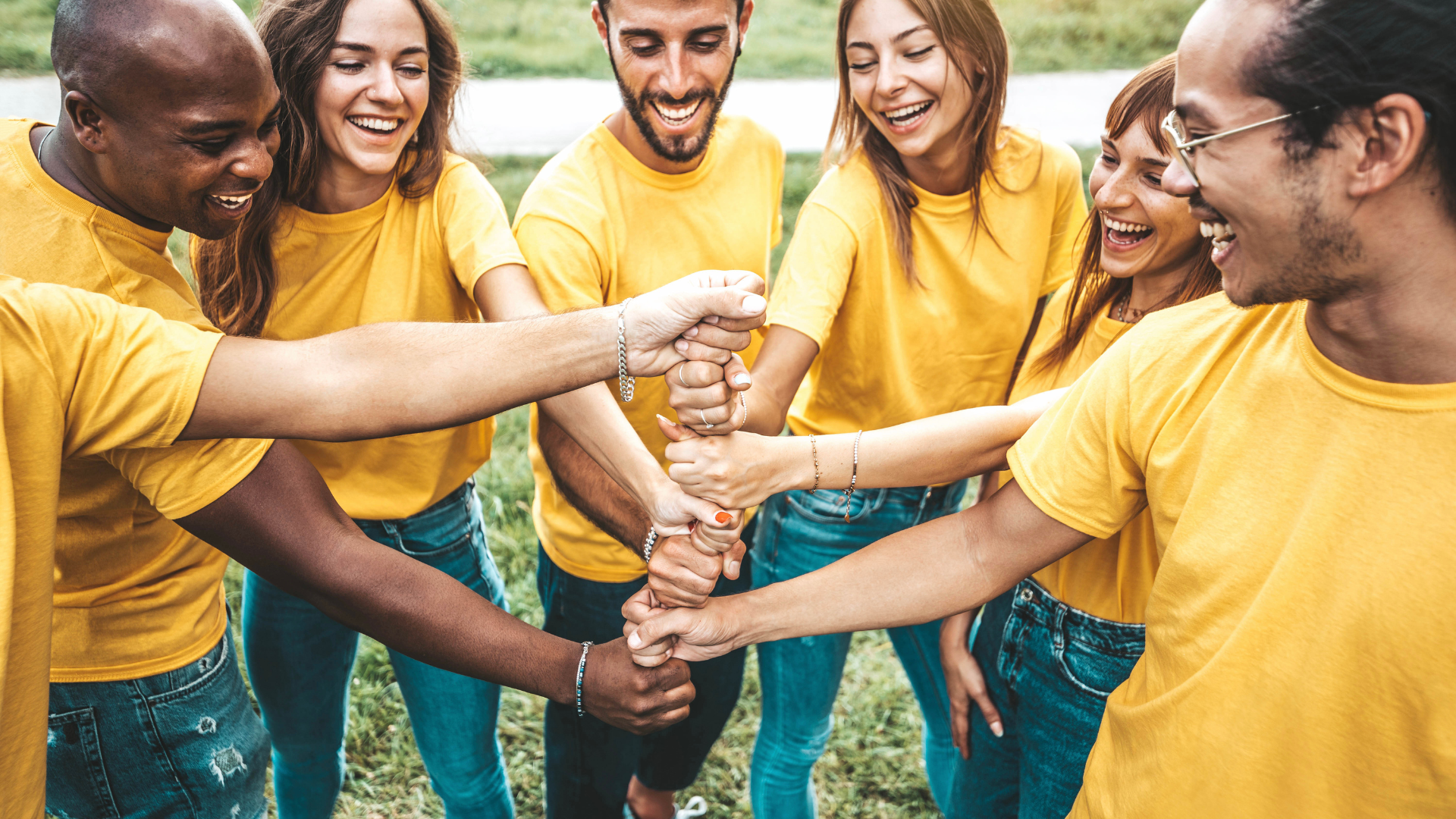 A group of people are putting their hands together in a circle.