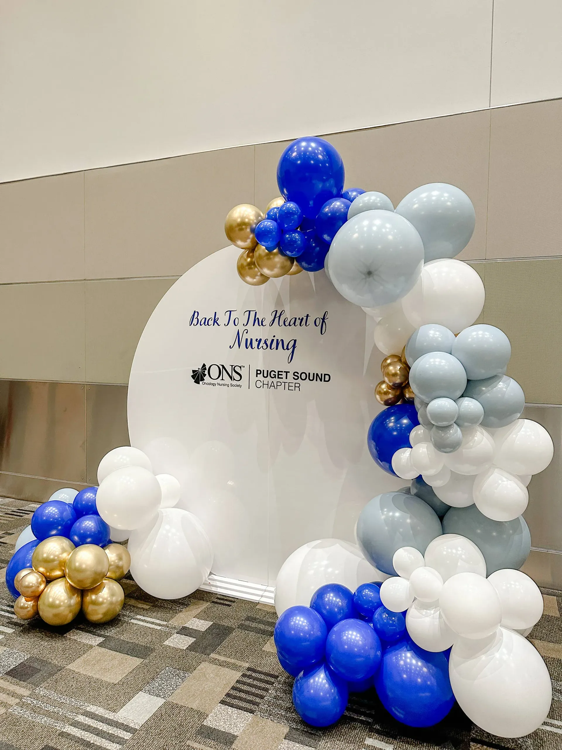 A bunch of blue and white balloons are sitting on the floor.