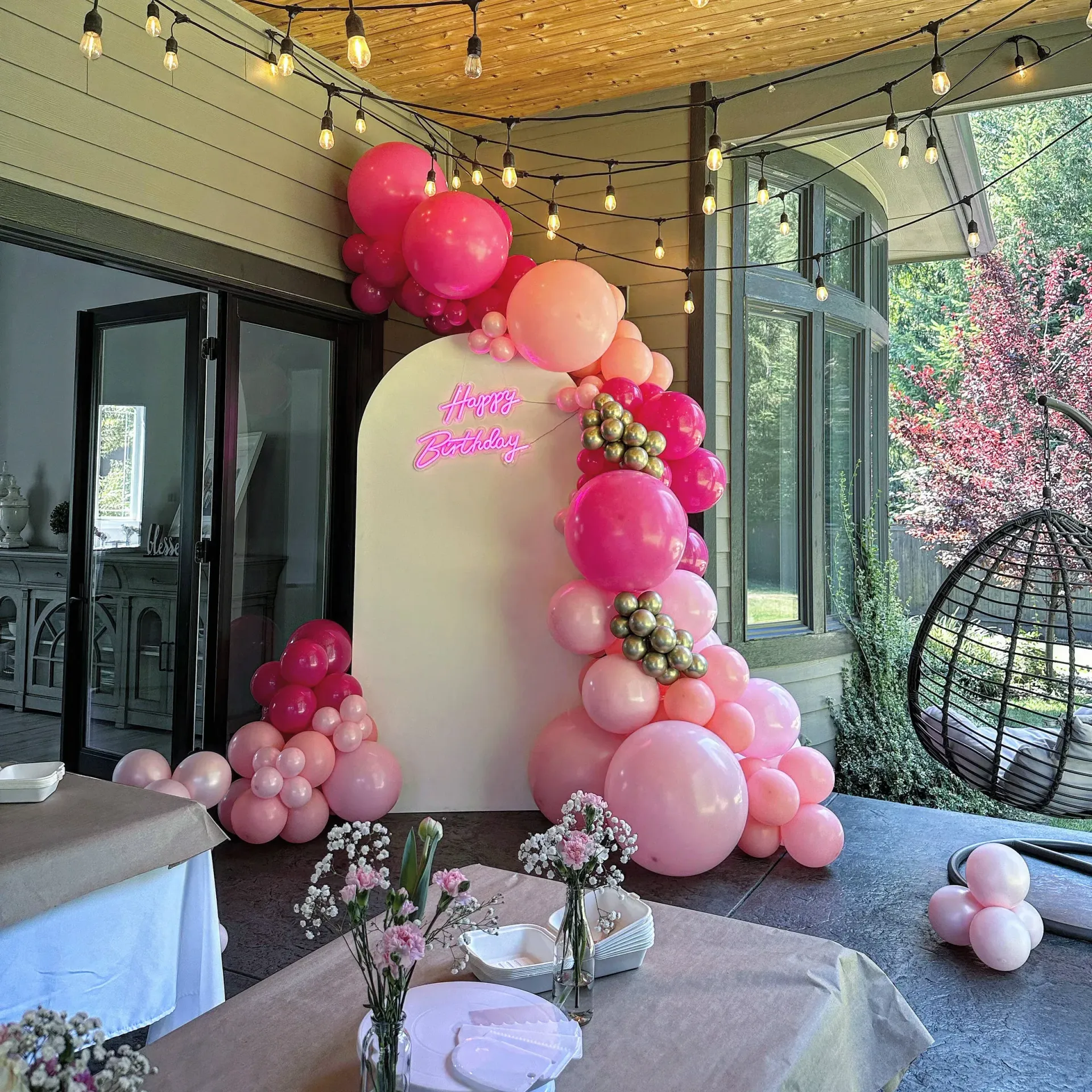 A room filled with pink balloons and flowers.