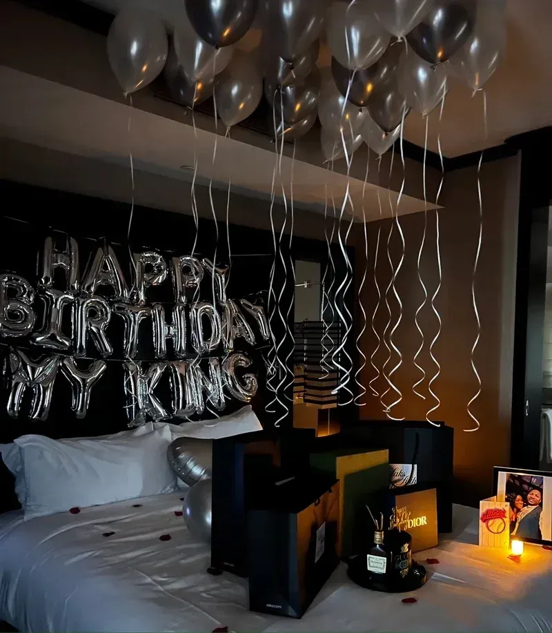 A bedroom decorated with balloons that say happy birthday my king
