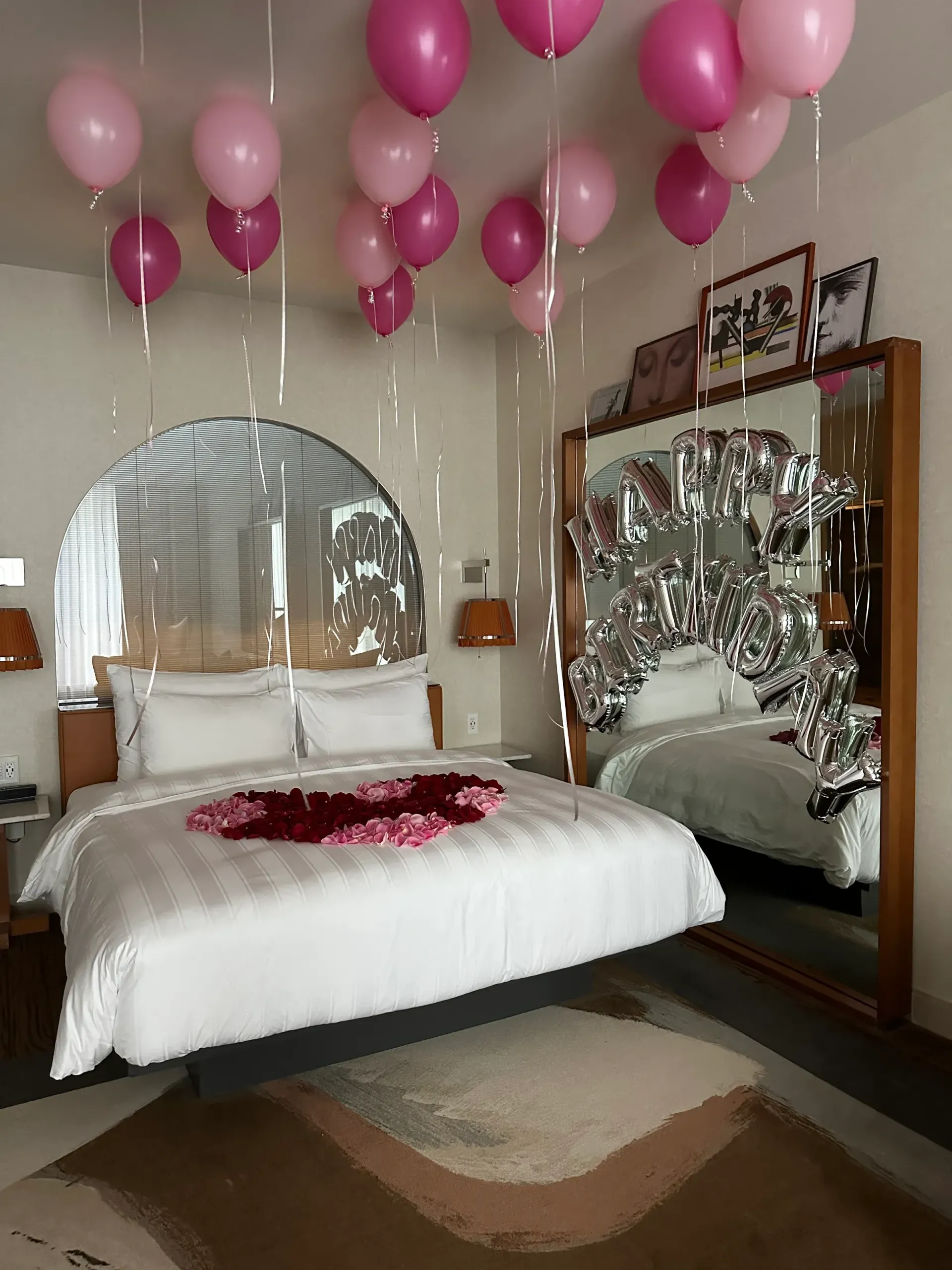 A bedroom with a bed and balloons hanging from the ceiling