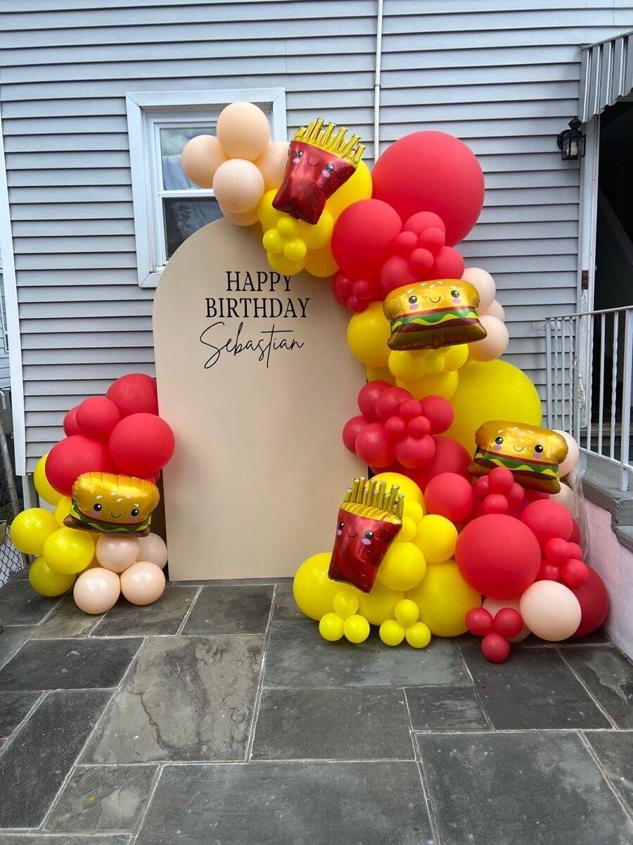 A happy birthday sign is surrounded by balloons