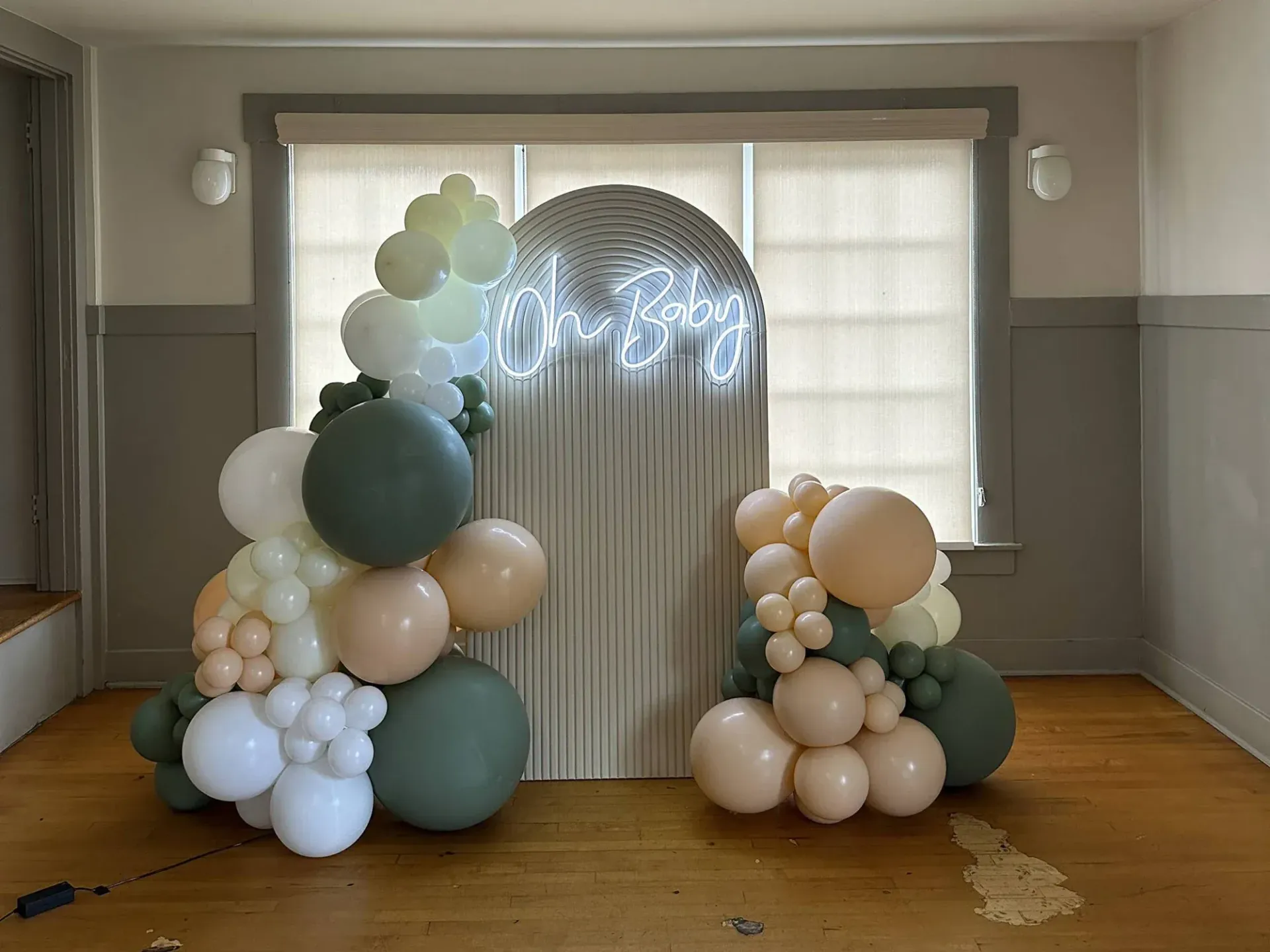 A room filled with balloons and a neon sign.