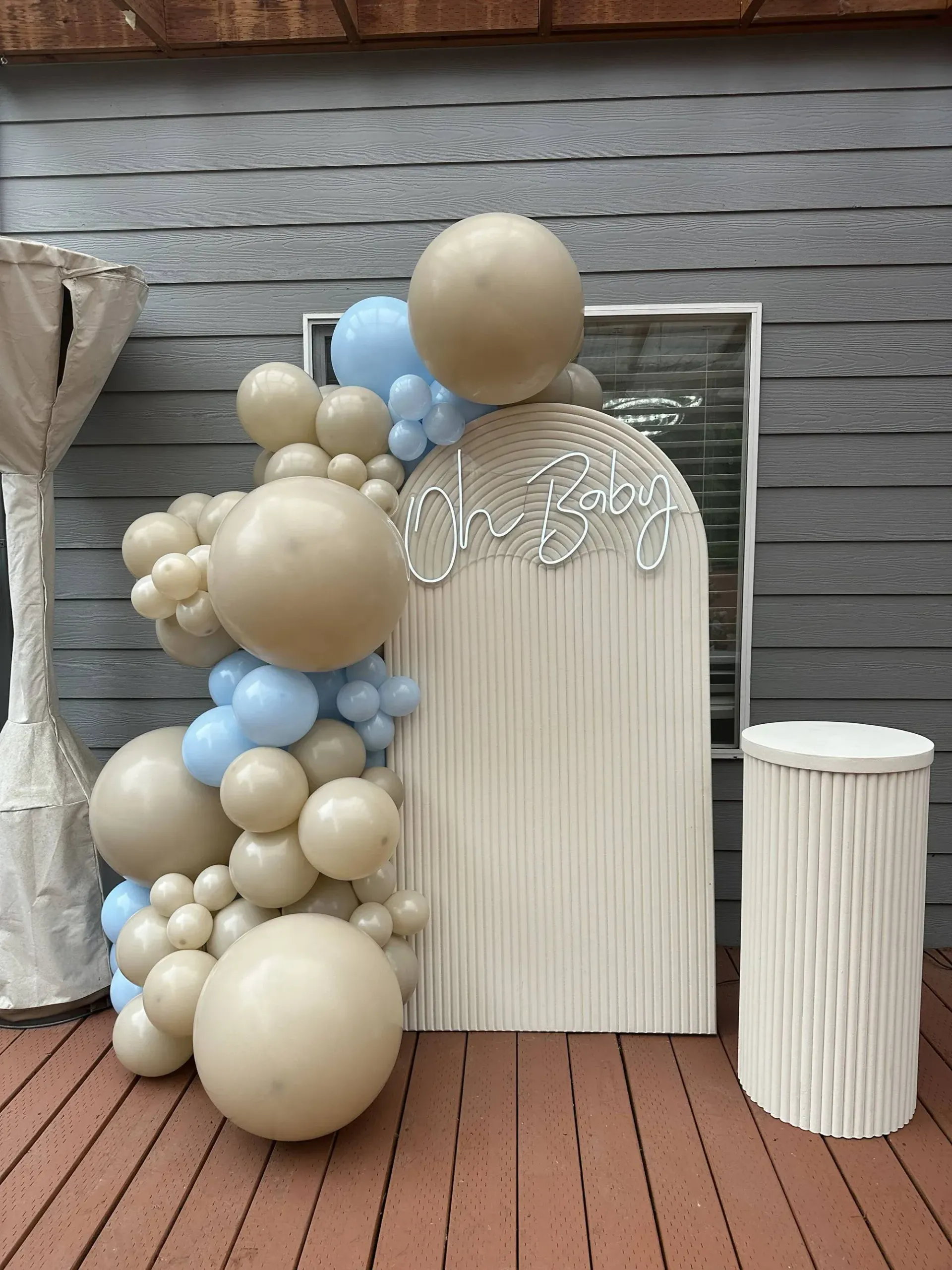 A bunch of balloons are sitting on a wooden deck.