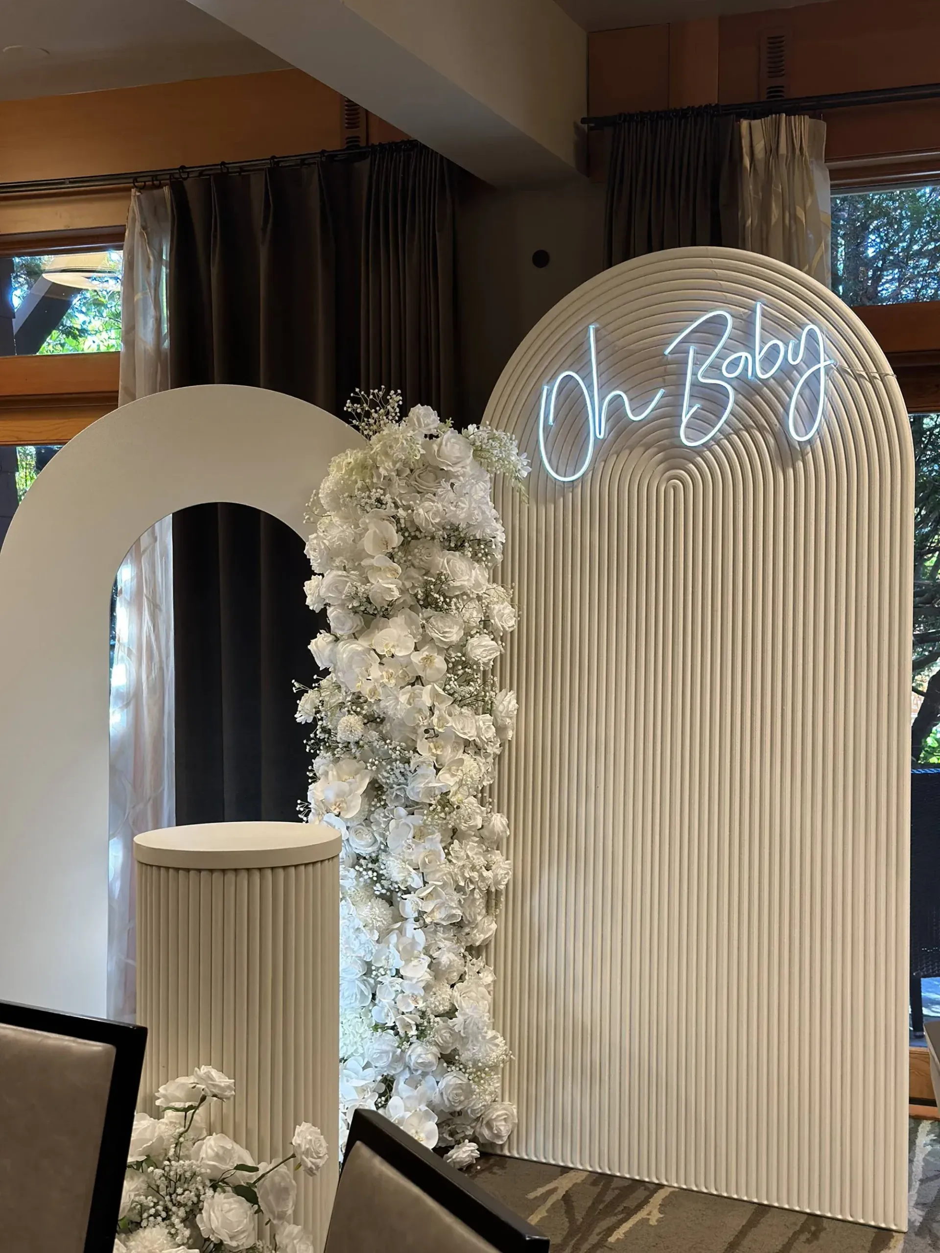 A room decorated for a baby shower with a neon sign that says `` oh baby ''.