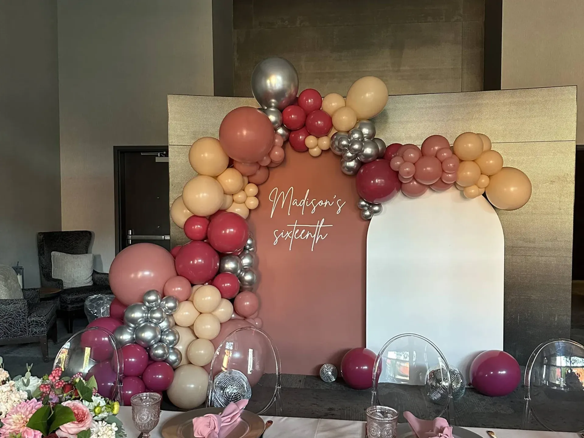 A room decorated with balloons and flowers for a birthday party.