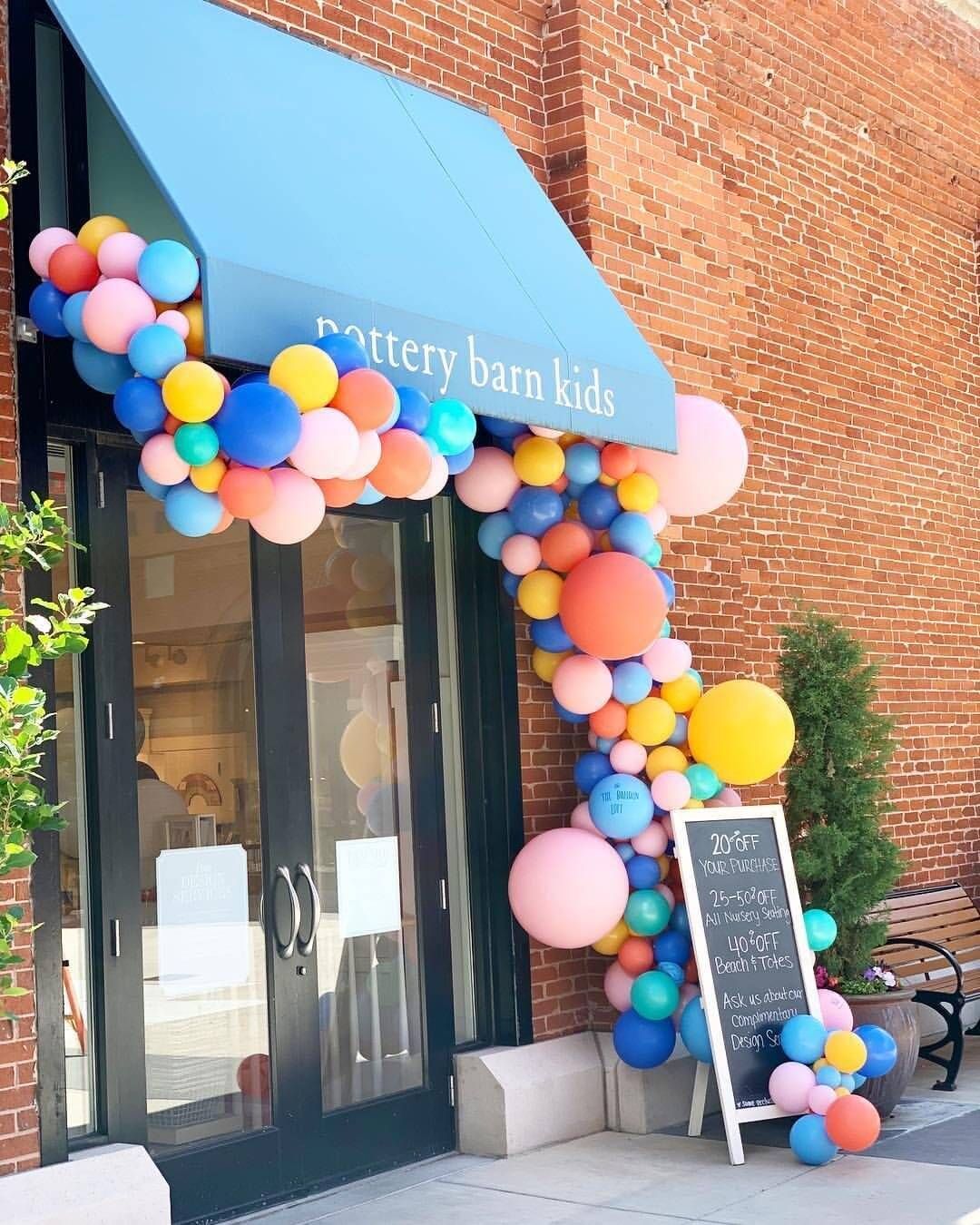 A store front with balloons and an awning that says pottery barn kids