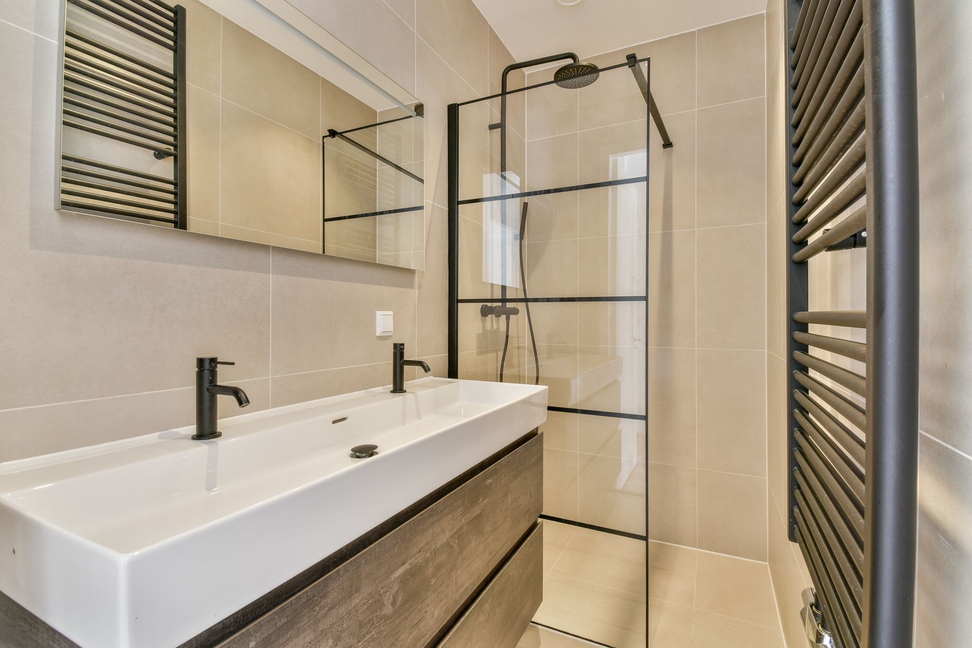 Modern bathroom with a double sink, black fixtures, and a glass shower.