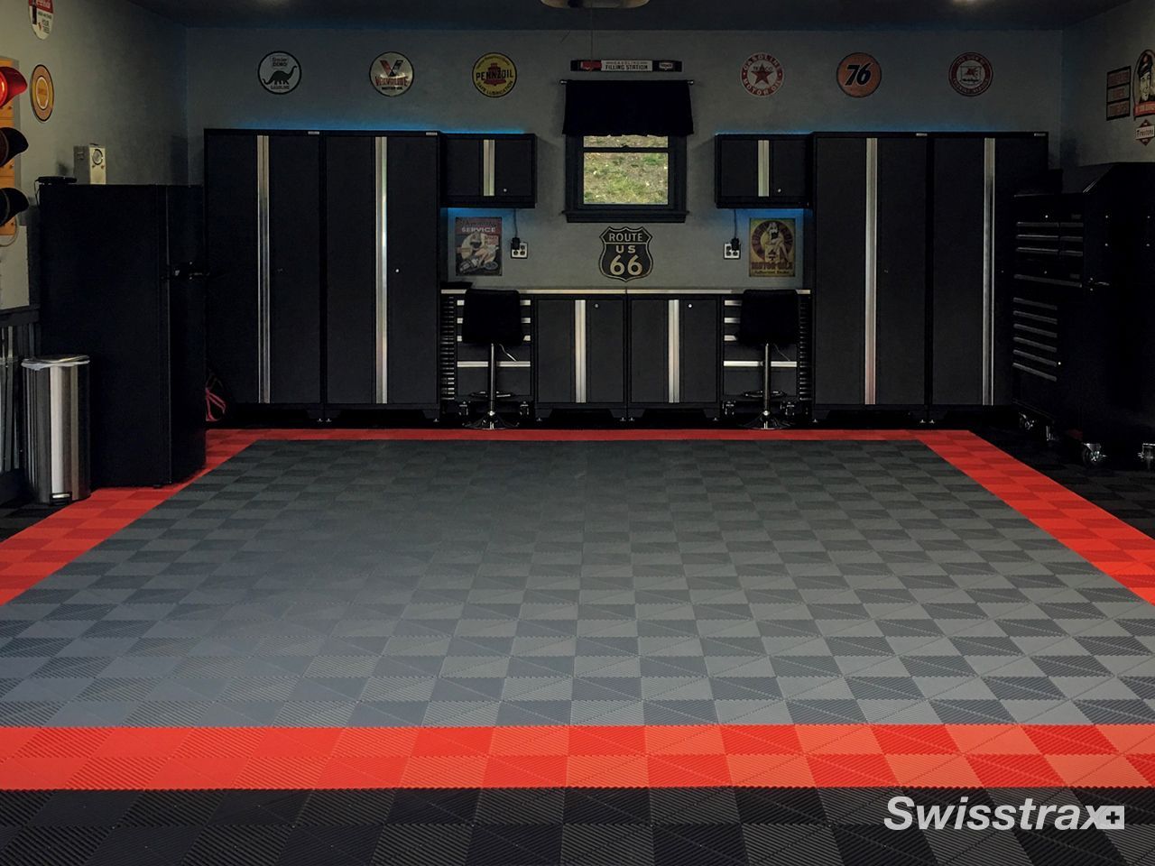 Empty martial arts training room with gray mat flooring and red border padding, viewed from the front