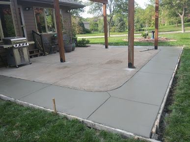 A patio is being built in the backyard of a house.