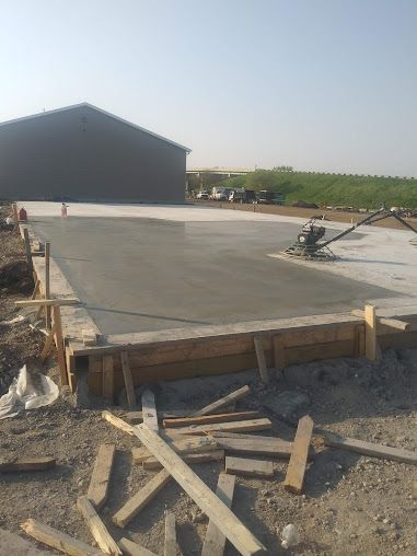 A concrete driveway is being built in front of a building.