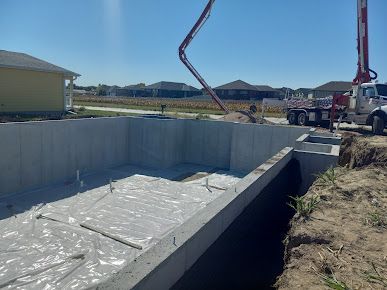 A concrete pump is being used to pour concrete into a swimming pool.