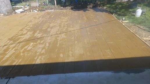 A concrete floor is being built in a backyard.