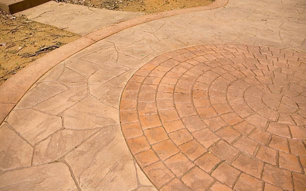 A close up of a concrete walkway with a circular pattern.