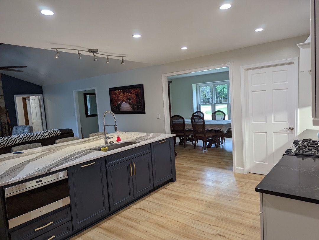 A kitchen with a large island and a dining room in the background.