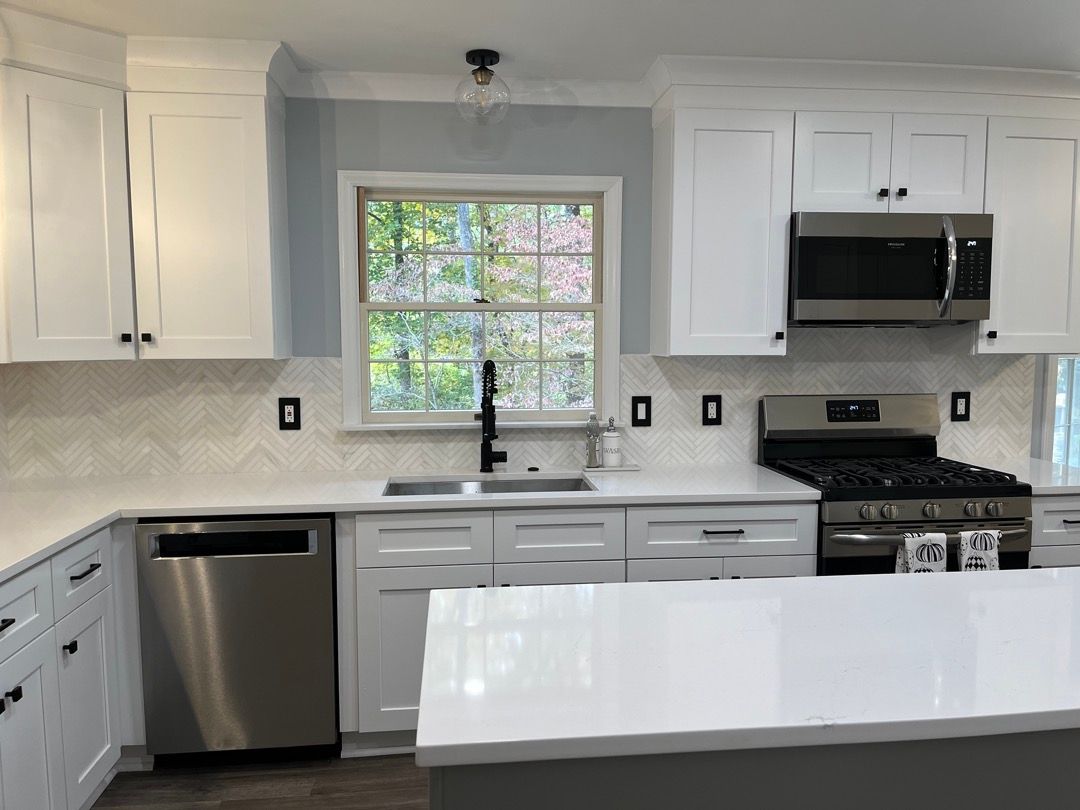 A kitchen with white cabinets and stainless steel appliances