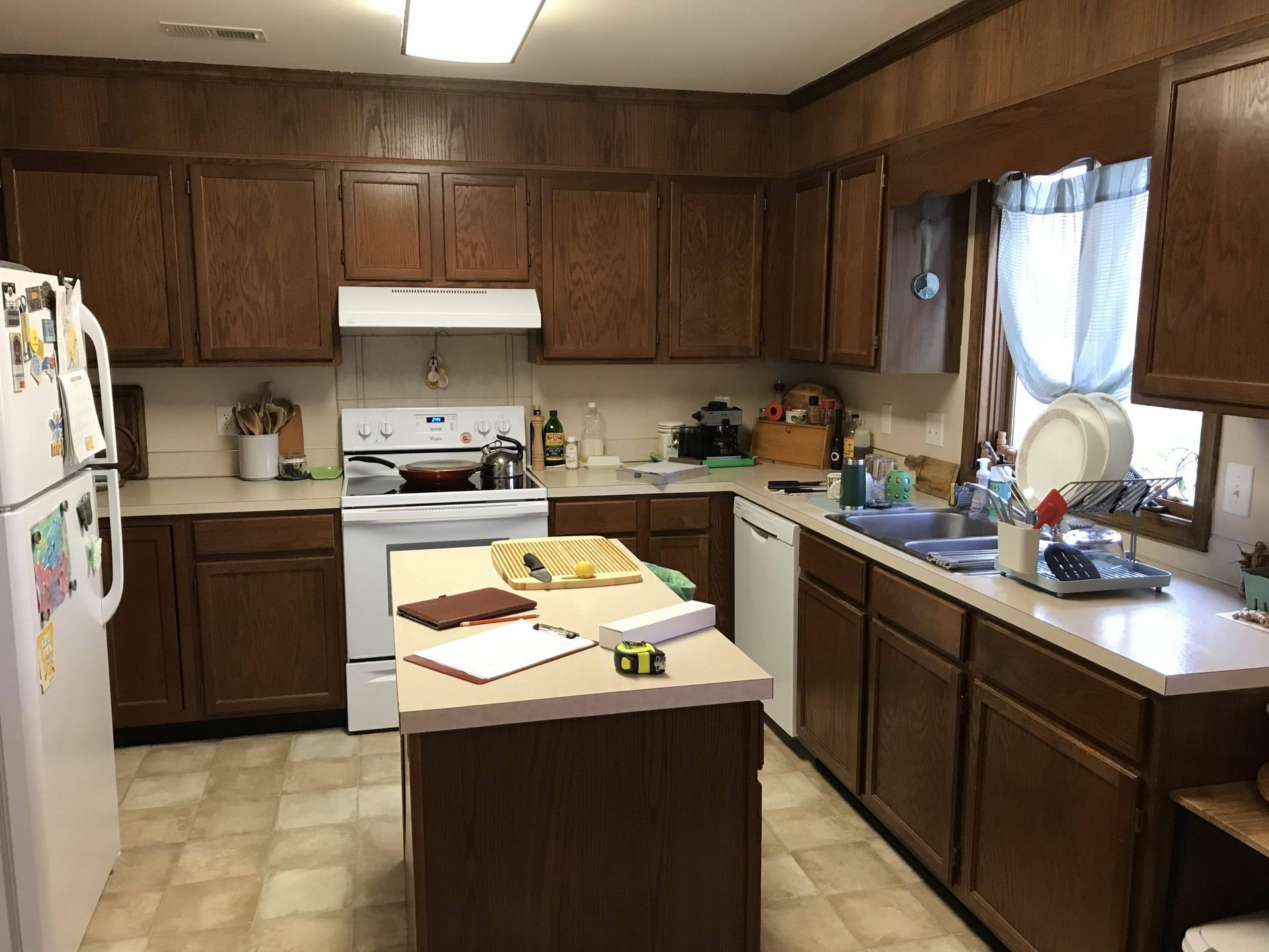 A kitchen with wooden cabinets and a white refrigerator