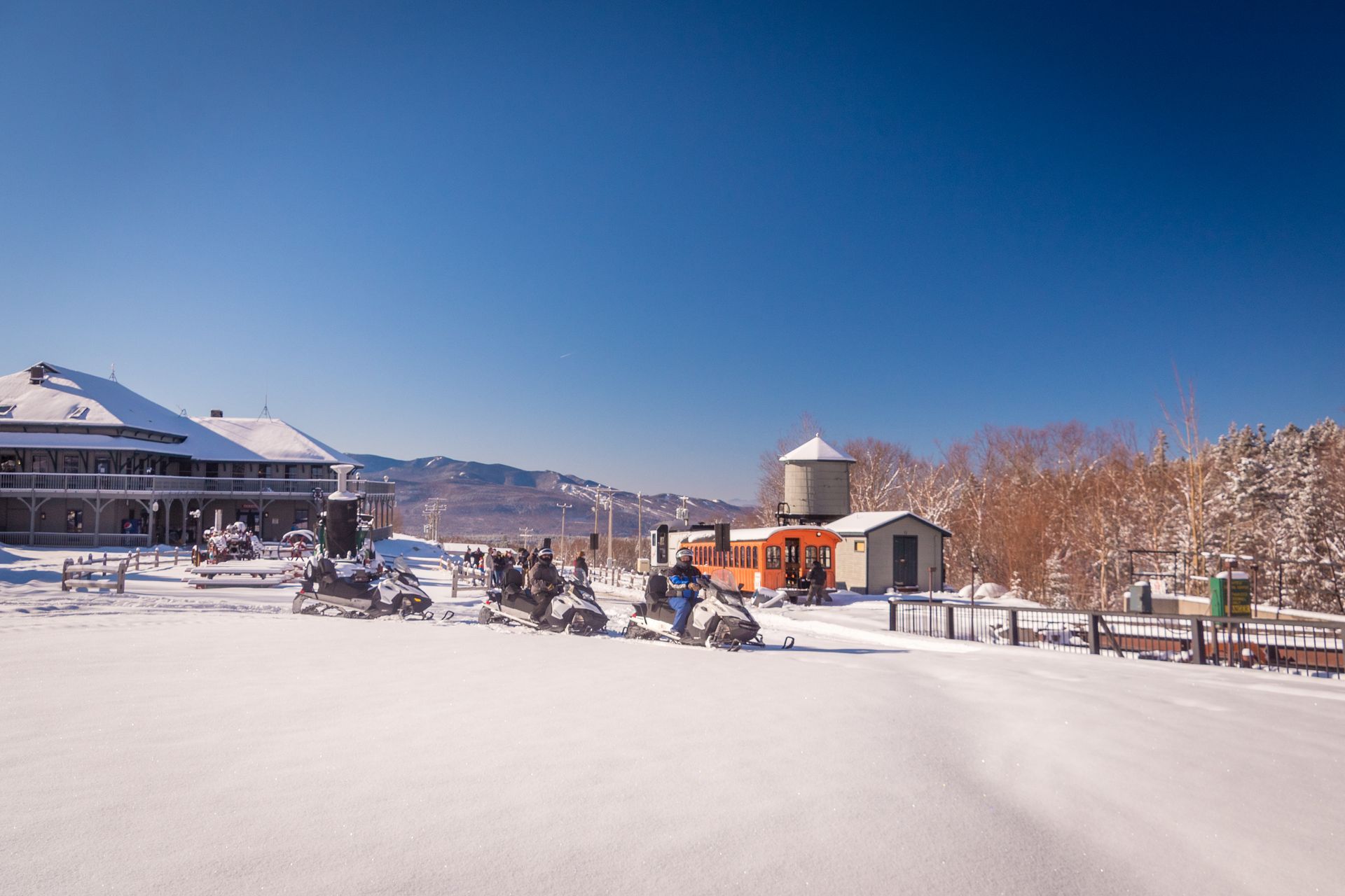 snowmobiles are parked in the snow in front of a building