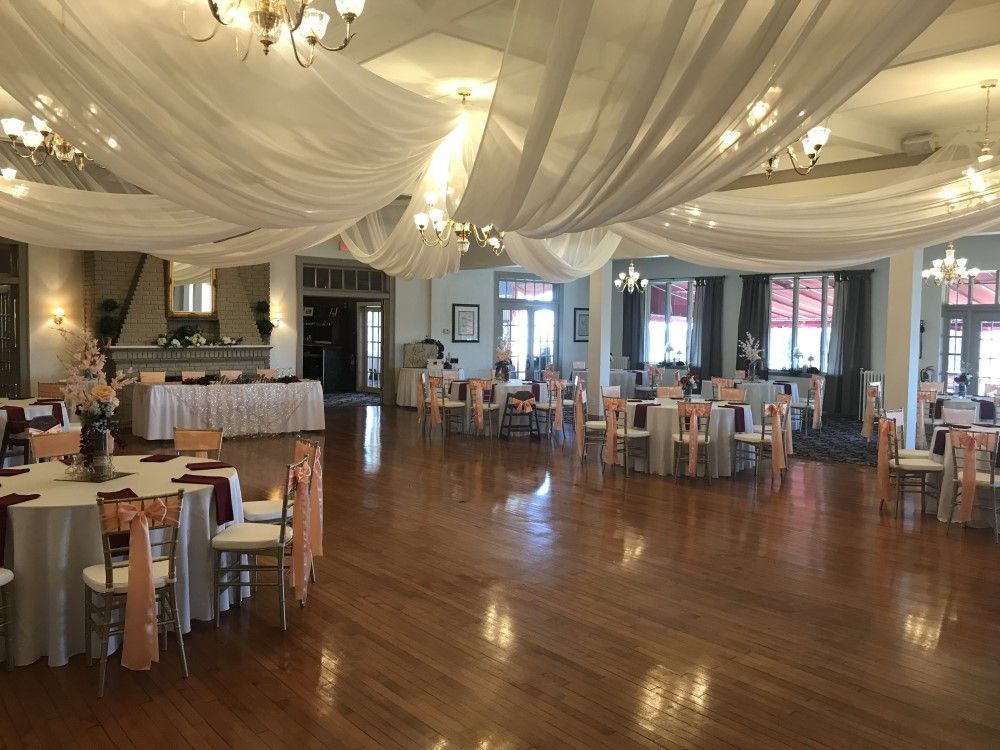 A large room with tables and chairs set up for a wedding reception.