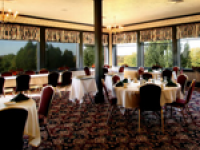 A dining room with tables and chairs and lots of windows