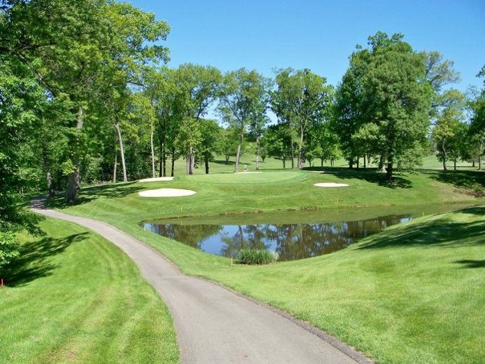 A golf course with a pond in the middle of it