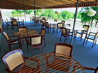 A patio with tables and chairs under a canopy.
