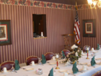 A long table in a room with a flag on the wall.