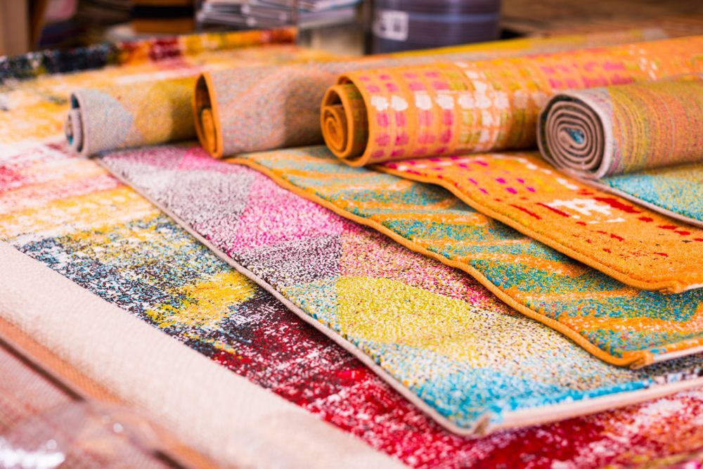 A Bunch Of Colourful Rugs Are Stacked On Top Of Each Other — InHouse Homewares in Forster, NSW