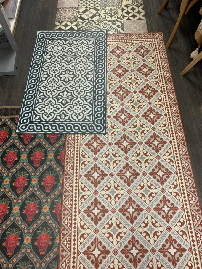 A Row Of Rugs With Different Patterns On Them Are Sitting On A Wooden Floor — InHouse Homewares in Forster, NSW
