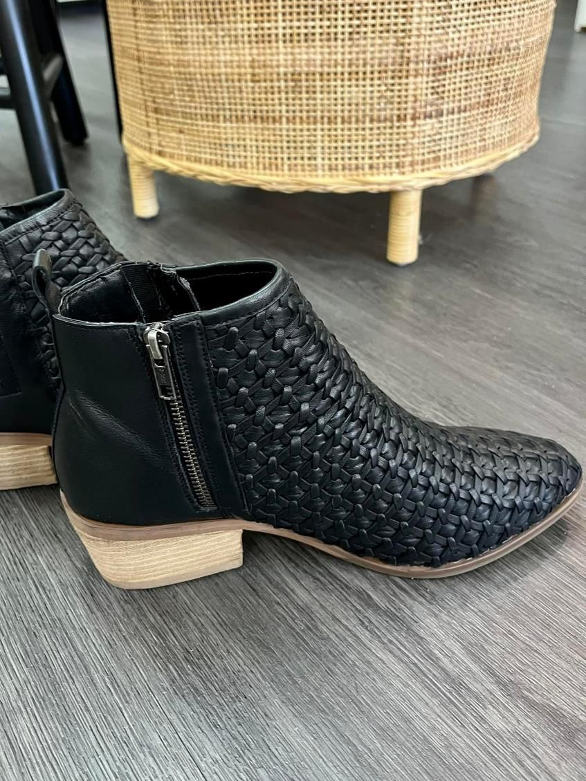A Pair Of Black Ankle Boots Are Sitting On A Wooden Floor — InHouse Homewares in Forster, NSW