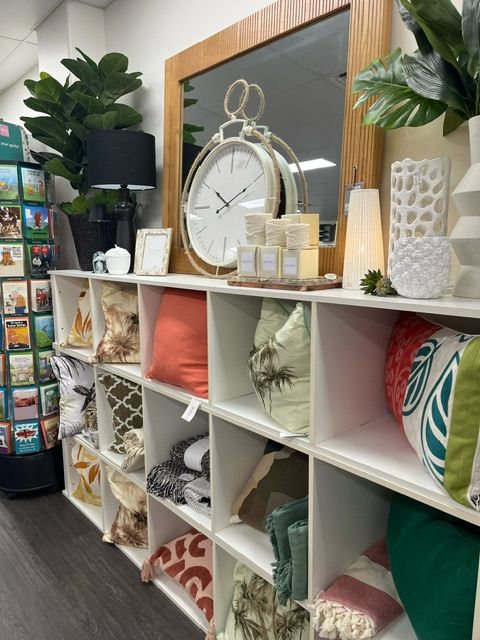 A Shelf Filled With Lots Of Pillows And A Clock — InHouse Homewares in Forster, NSW