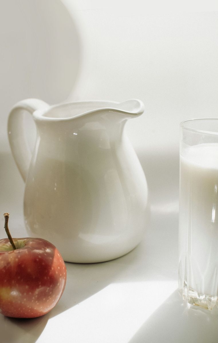 A pitcher of milk a glass of milk and an apple on a table — InHouse Homewares in Forster, NSW