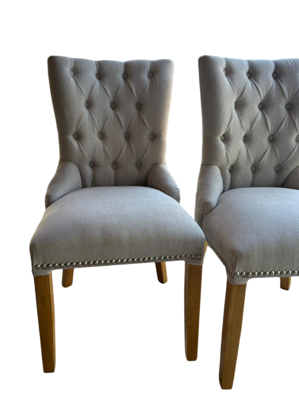 Silla de comedor tapizada en azul marino con capitoné y ribete tachonado.