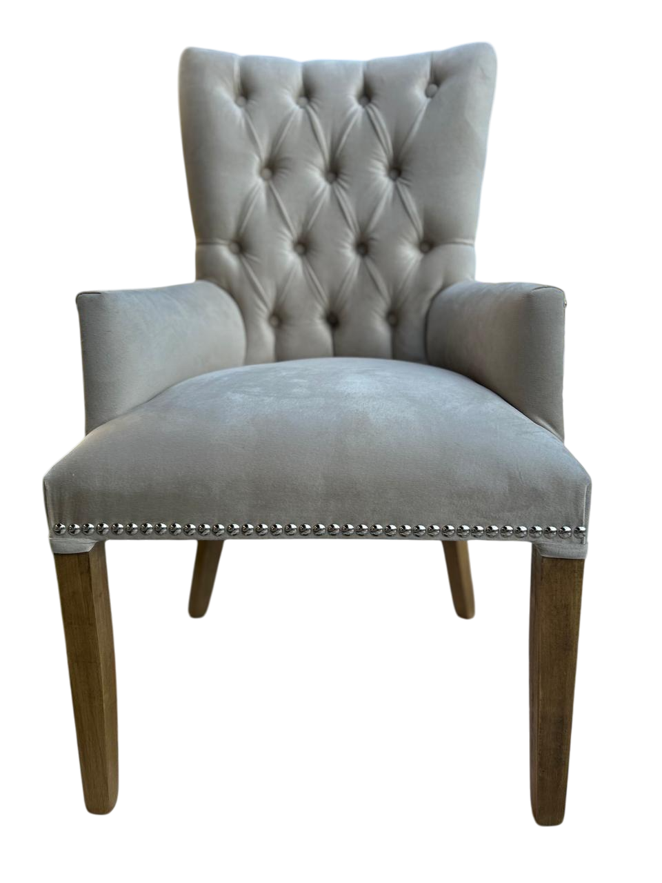 Silla de comedor tapizada en gris con capitoné en el respaldo y ribete de tachuelas en el asiento.