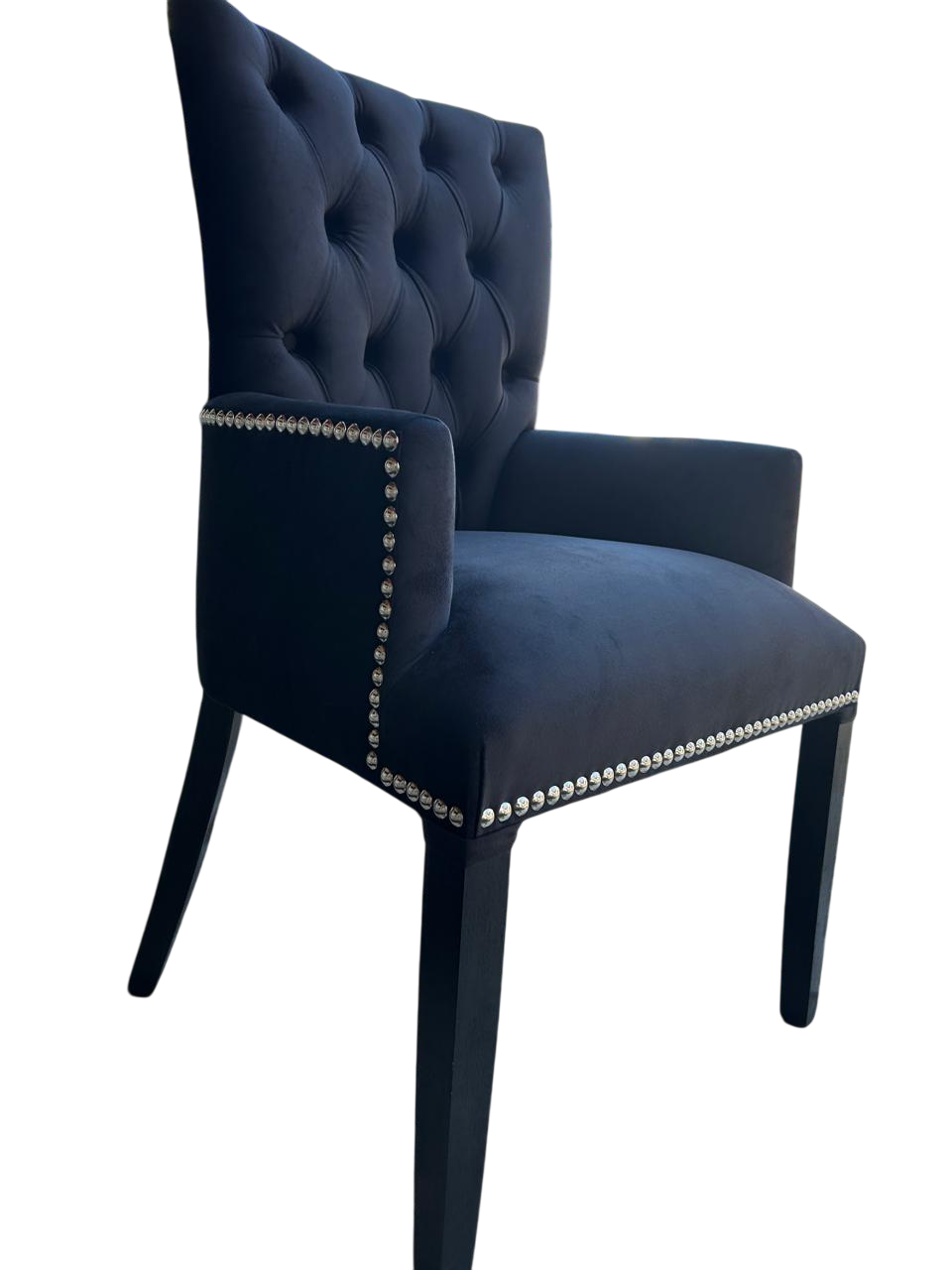 Silla de comedor tapizada en gris con capitoné en el respaldo y ribete de tachuelas en el asiento.