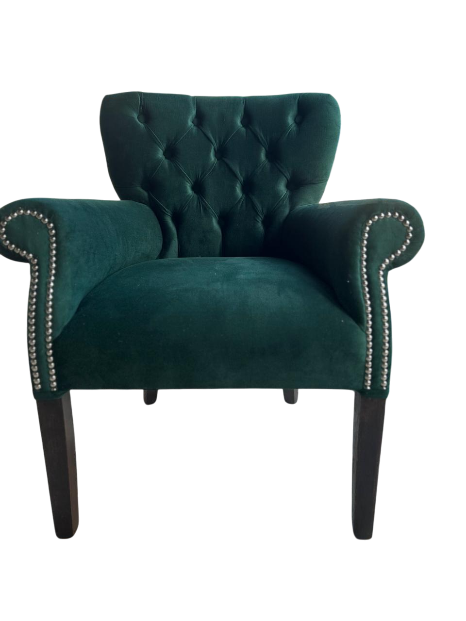 Sillón capitoné verde esmeralda con patas de madera oscura y ribete tachonado.